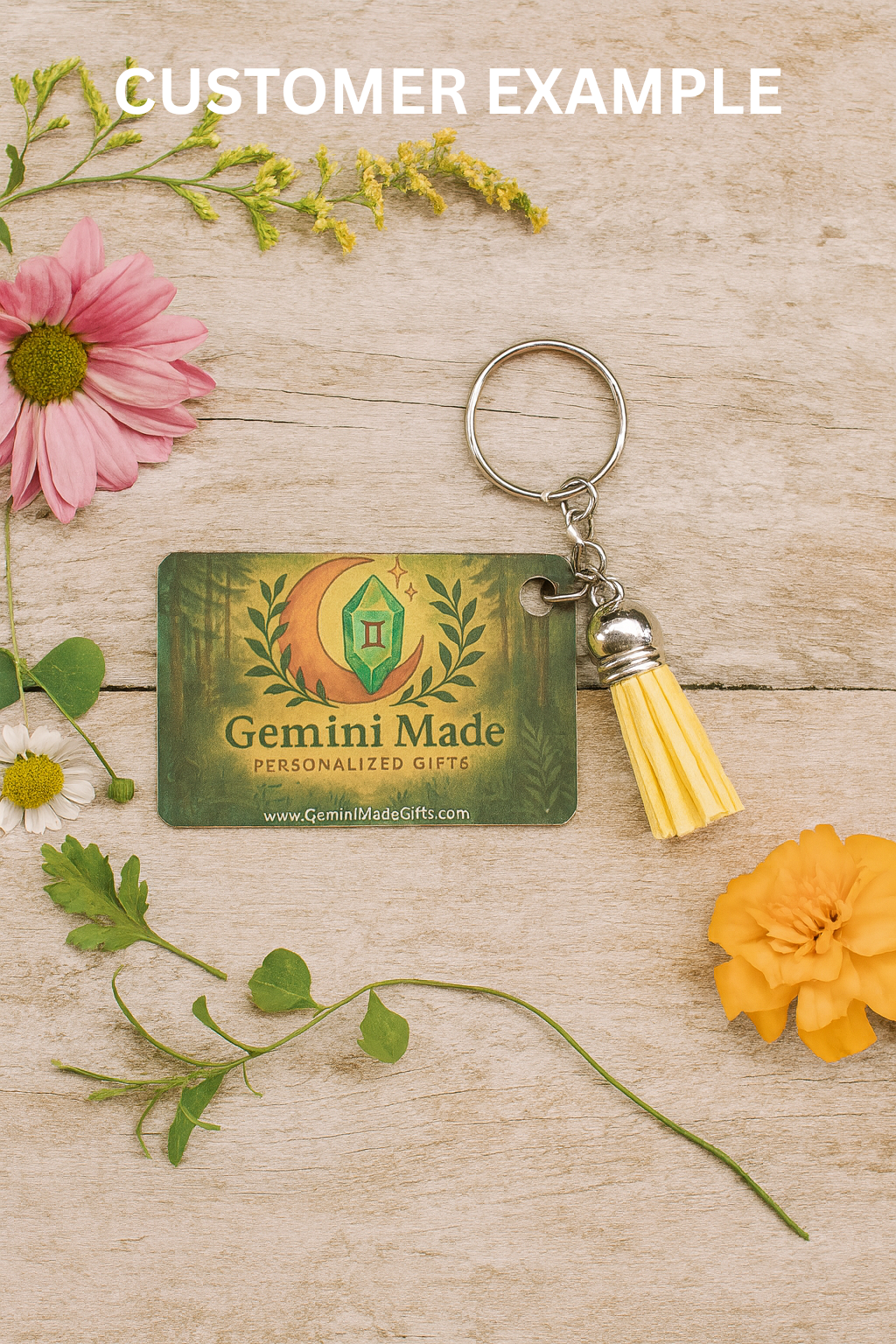 Keychain with Gemini Made tag on a wooden surface with flowers