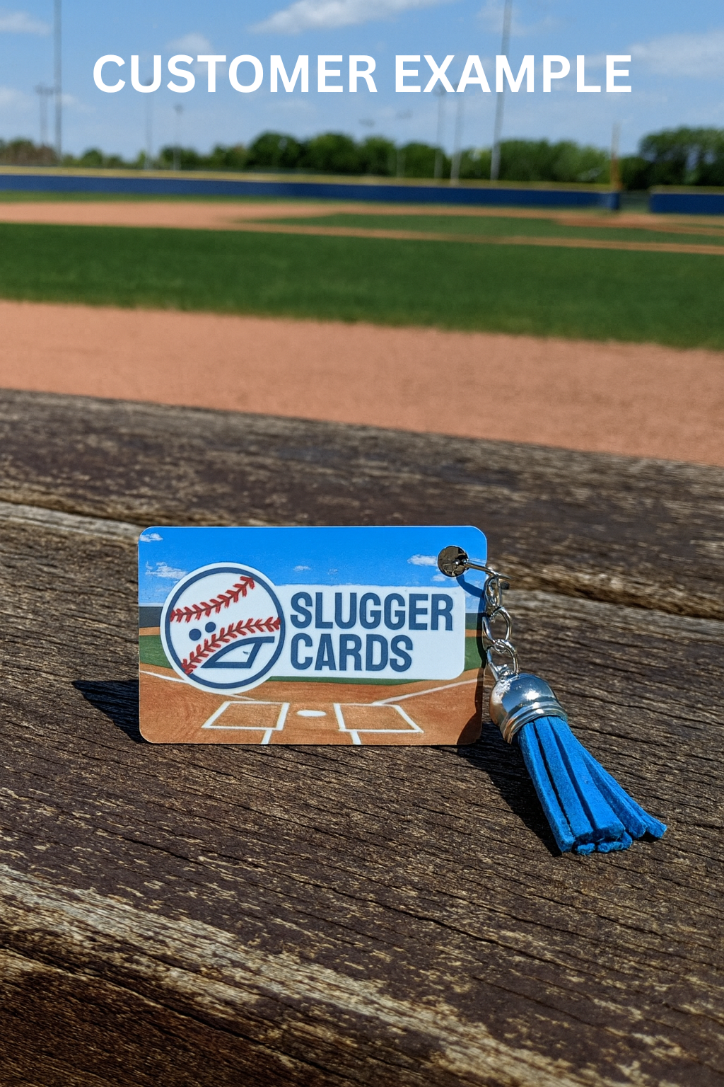 Slugger Cards keychain on a wooden surface with a baseball field background